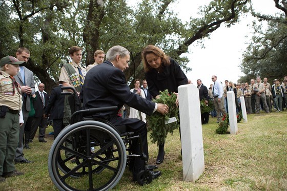 Governor Abbott and First Lady, Cecilia, place a wreath on a grave
