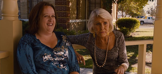 Movie still of actresses conversing outside of Bastrop County Courthouse