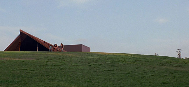 Movie Still of Man, young boy and girl playing in the field in from of Miller Outdoor Theatre