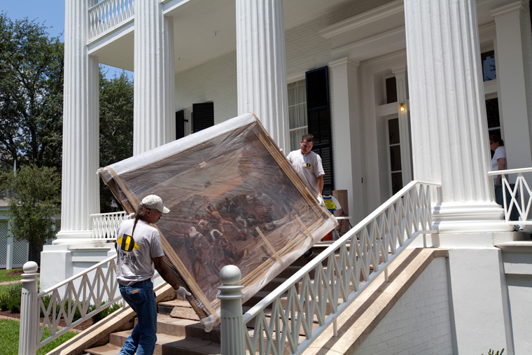 Workers move 18th century painting back to its home in the Mansion